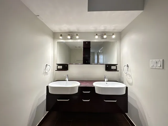 a bathroom with a double sink sink and a mirror
