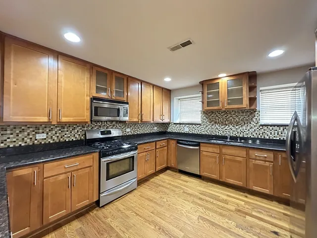 a kitchen with stainless steel appliances granite countertop wooden cabinets a sink and dishwasher
