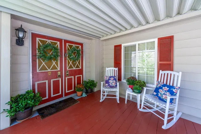 a porch area with furniture and potted plants