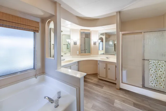 a bathroom with a bathtub a double vanity sink and a window