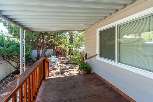 a front view of a house with a chairs and table in the patio
