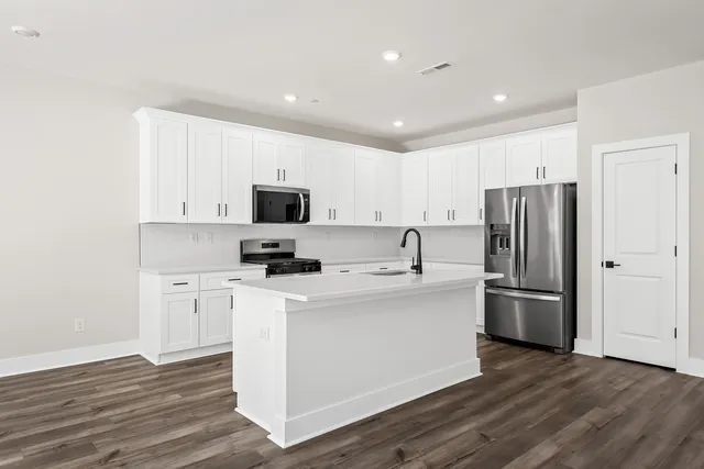 a kitchen with stainless steel appliances a refrigerator stove microwave and sink