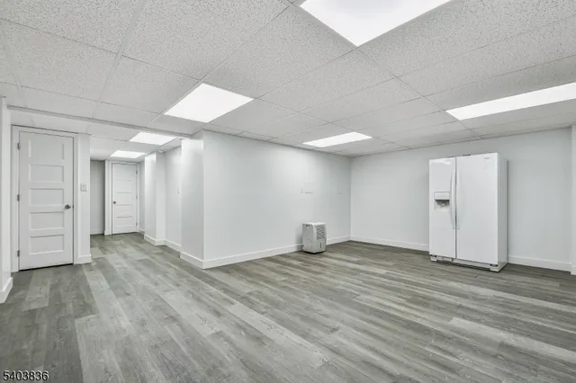an empty room with wooden floor & windows and bathroom
