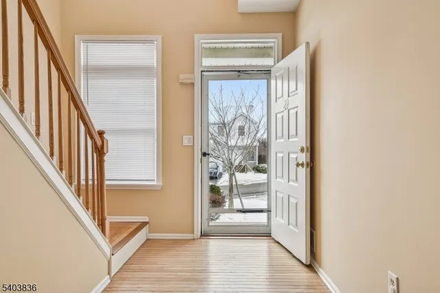 a view of a hallway with wooden floor and staircase