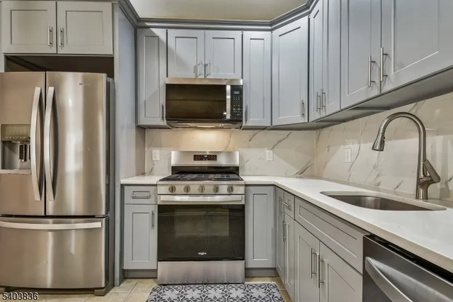a kitchen with cabinets stainless steel appliances and a sink