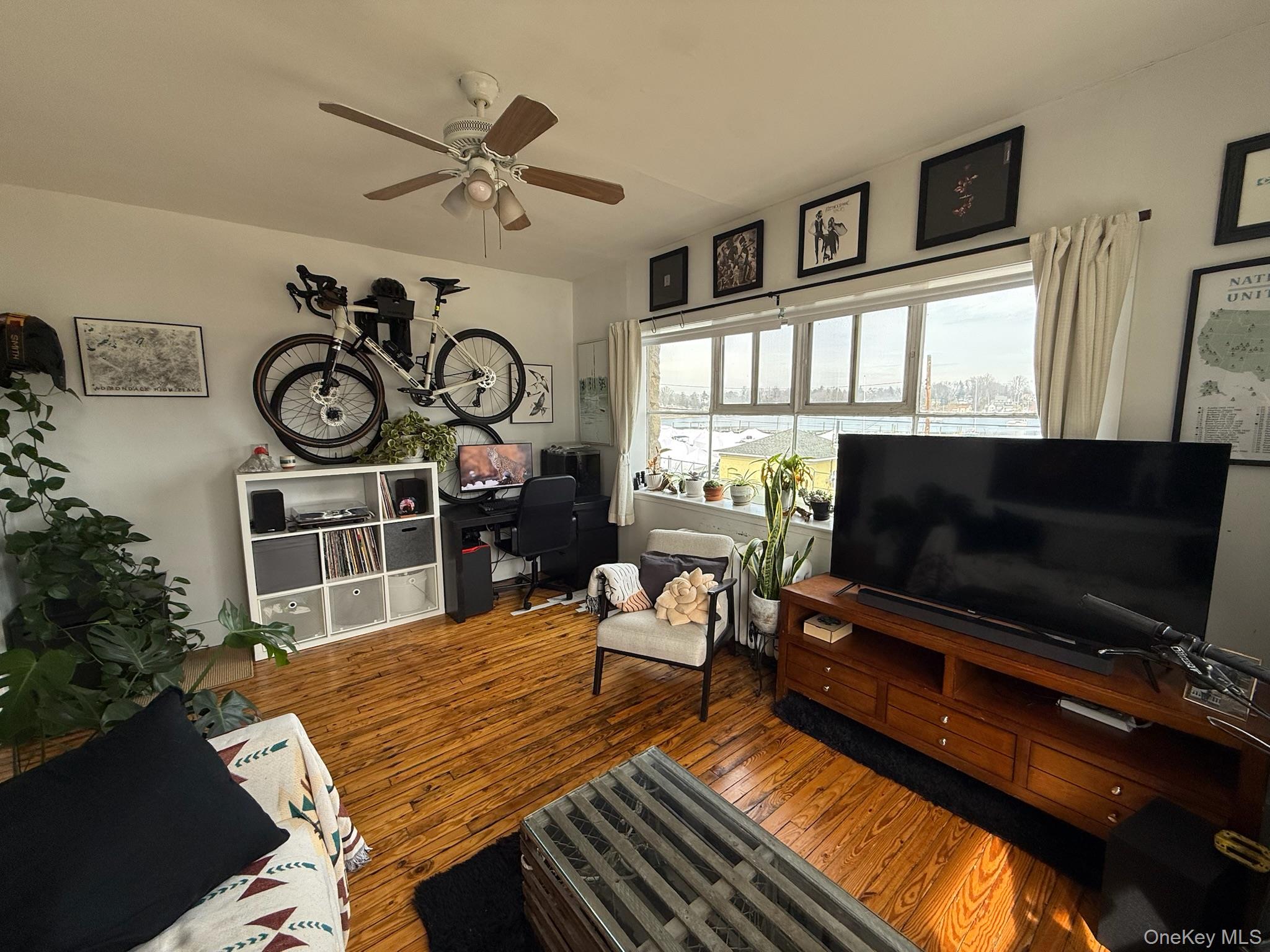 293 West Shore Road, Unit 1 Huntington, NY 11743 - Photo 6 of 13 a living room with furniture a flat screen tv and a floor to ceiling window