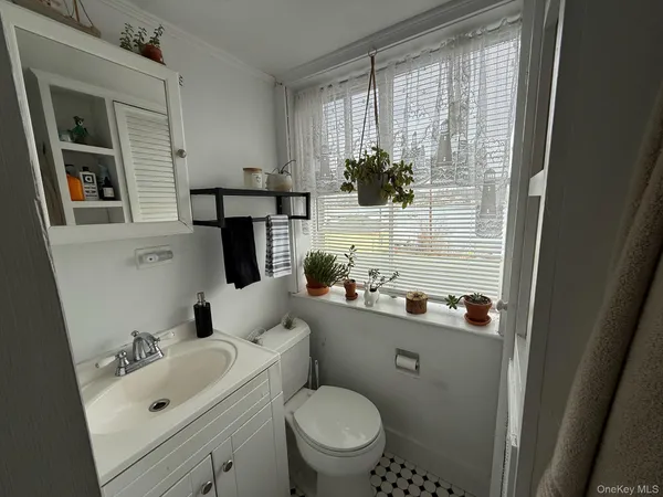 a bathroom with a sink a toilet and shower curtain