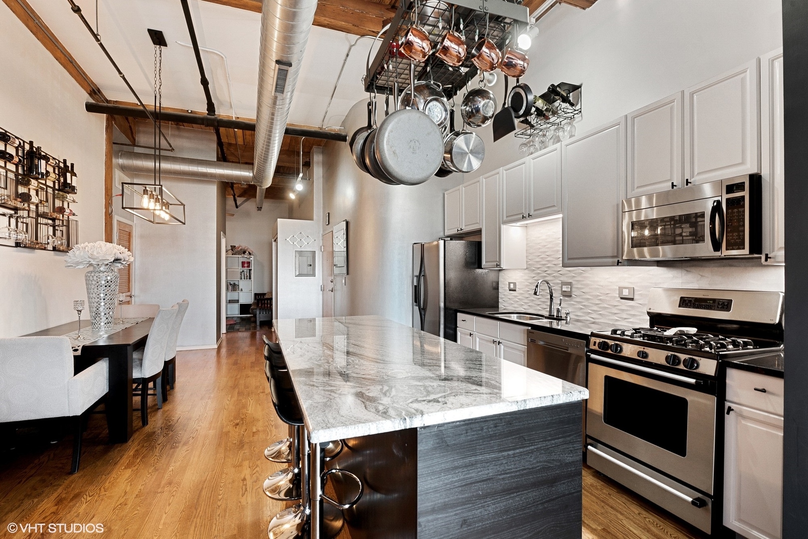 1500 West Monroe Street, Unit 623 Chicago, IL 60607 - Photo 4 of 11 a kitchen with stainless steel appliances granite countertop a sink a stove and a wooden floors