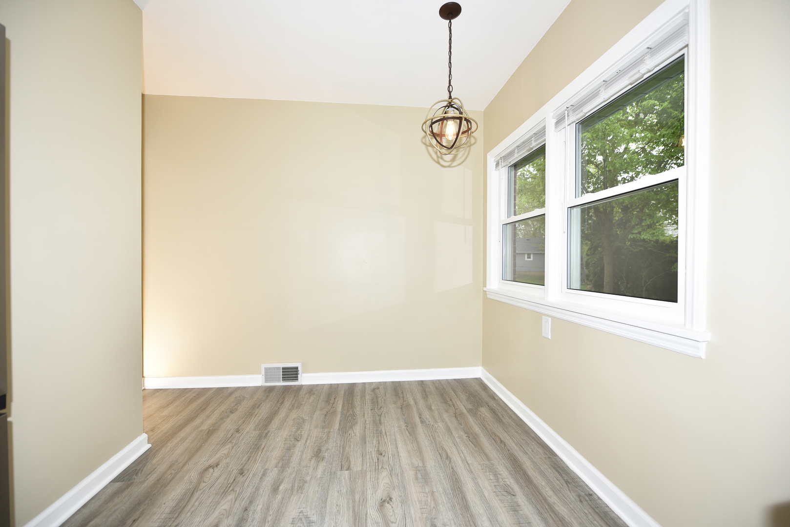 502 Manchester Road Normal, IL 61761 - Photo 5 of 29 an empty room with wooden floor and windows