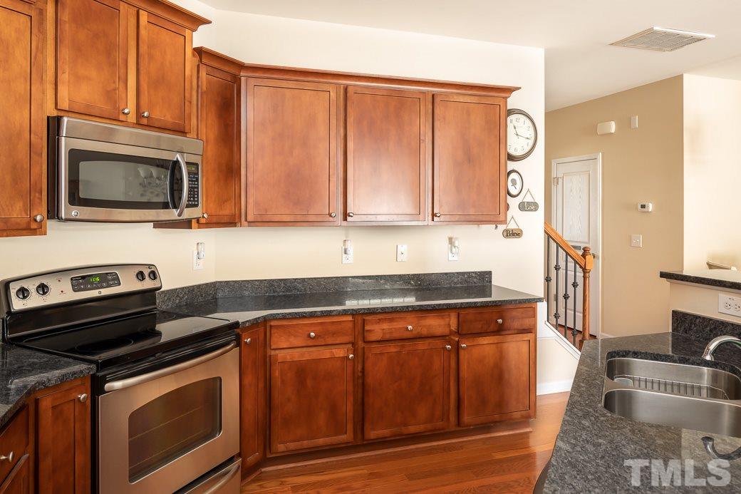 1345 Still Monument Way Raleigh, NC 27603 - Photo 5 of 28 a kitchen with granite countertop a stove sink and microwave