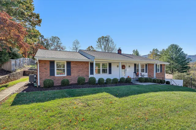 a front view of a house with a yard and trees