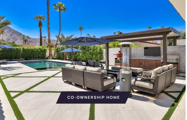 a view of a patio with couches table and chairs with potted plants