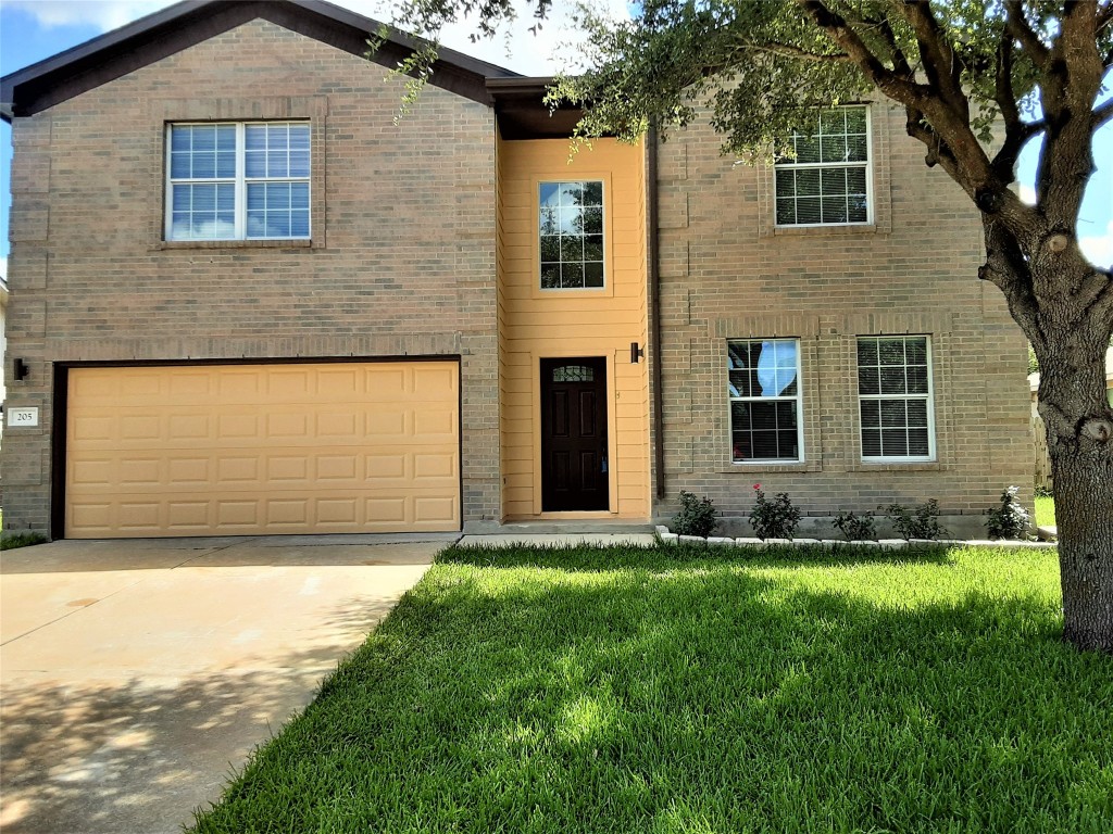 a front view of a house with a yard and garage