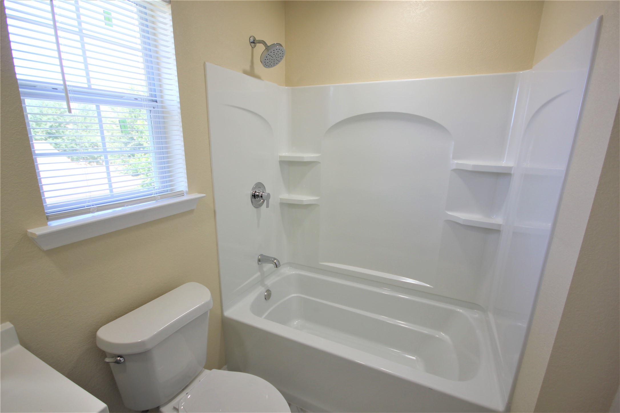 205 Rinehardt Street Hutto, TX 78634 - Photo 23 of 40 a white toilet sitting next to a bath tub