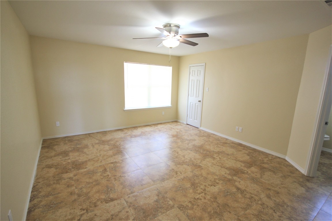 205 Rinehardt Street Hutto, TX 78634 - Photo 28 of 40 an empty room with windows and chandelier fan