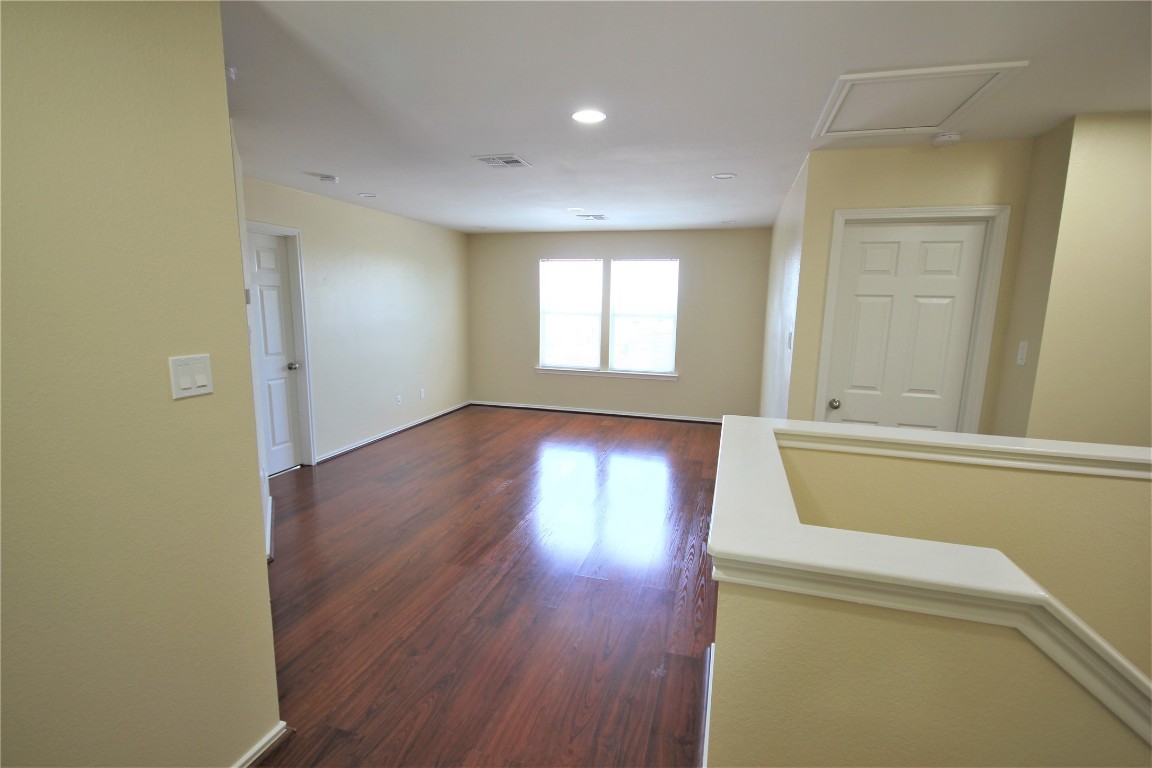 205 Rinehardt Street Hutto, TX 78634 - Photo 30 of 40 an empty room with wooden floor and windows