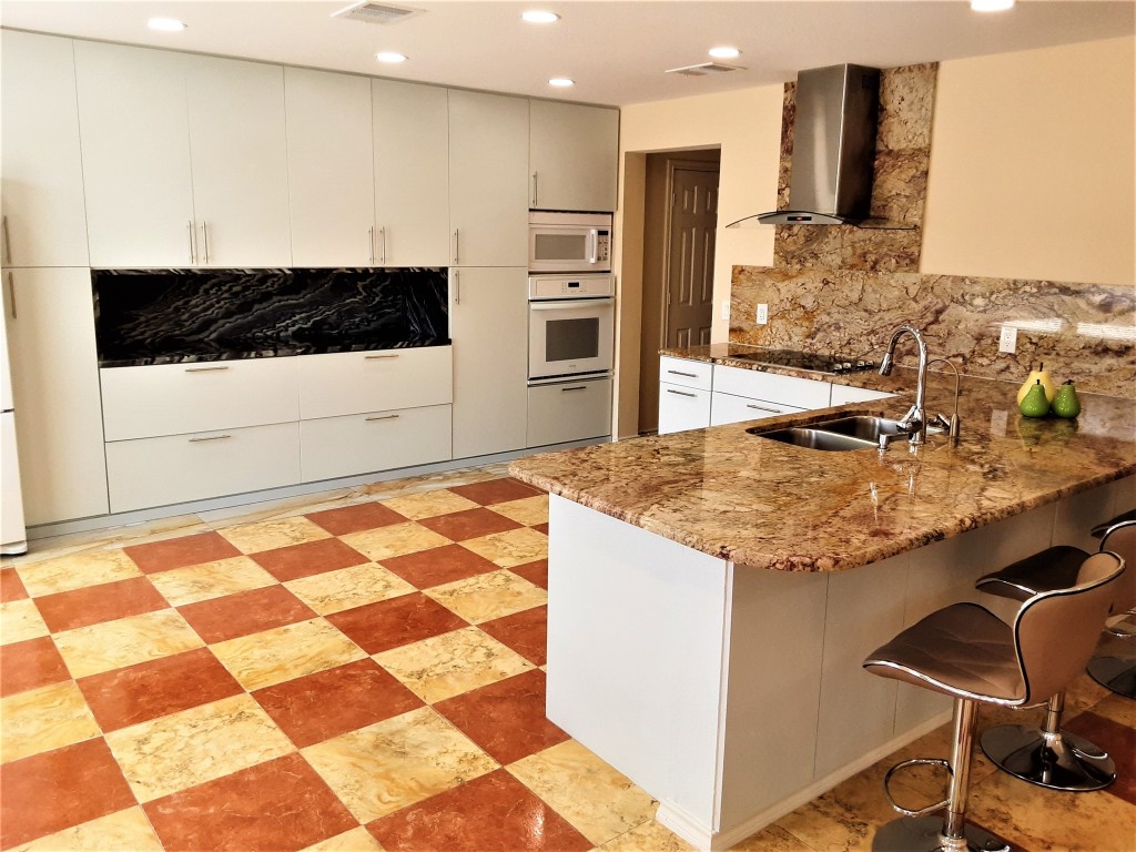 205 Rinehardt Street Hutto, TX 78634 - Photo 4 of 40 a kitchen with stainless steel appliances kitchen island granite countertop a sink and cabinets