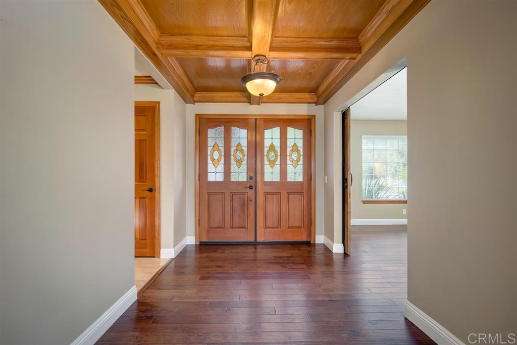 1054 Capra Way Fallbrook, CA 92028 - Photo 3 of 25 Gorgeous wood coffered ceiling with crown molding in the entryway and stained glass window inserts in the doors!