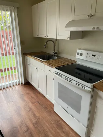 a kitchen with granite countertop white cabinets and white appliances