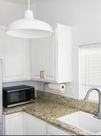 a kitchen with granite countertop a sink and a stove top oven