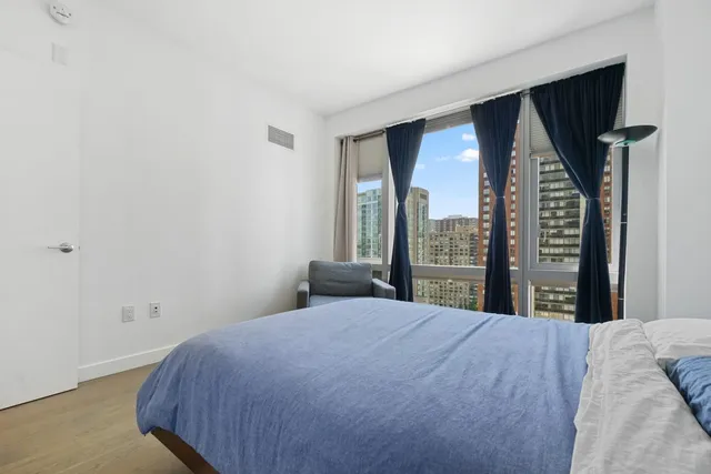 a bedroom with a large window and walk in closet