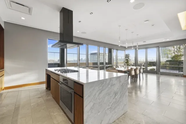 a kitchen with kitchen island granite countertop a table chairs sink and cabinets