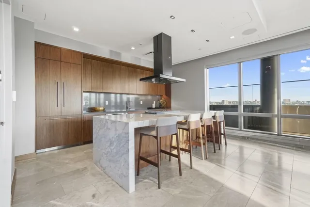 a large kitchen with stainless steel appliances granite countertop a lot of counter space and a sink
