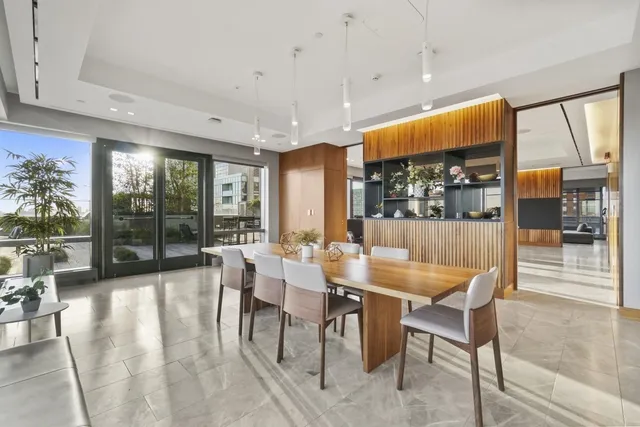 a dining hall with stainless steel appliances a dining table chairs and view living room