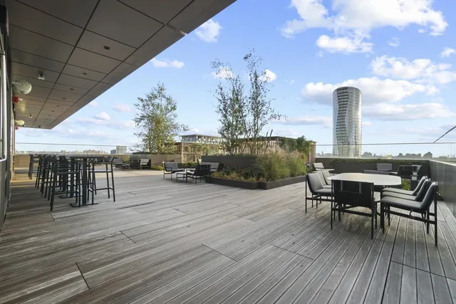 a living room with furniture large window and wooden floor