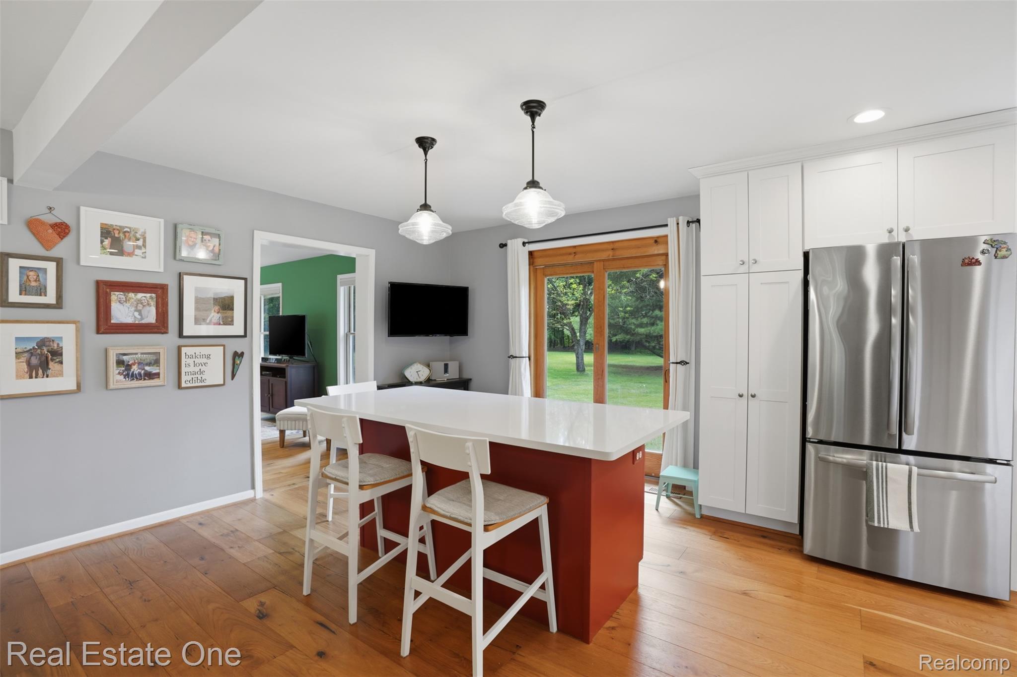 1765 Rowe Road Milford, MI 48380 - Photo 10 of 61 Kitchen featuring a red island with a white countertop, two pendant lights, and wood-finish flooring
