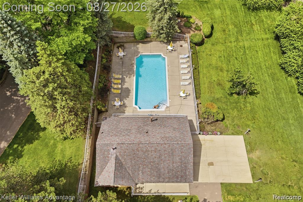 29726 Pine Ridge Circle Farmington, MI 48331 - Photo 41 of 42 Outdoor swimming pool with concrete surround, fenced perimeter, and adjacent building with dark shingle roof