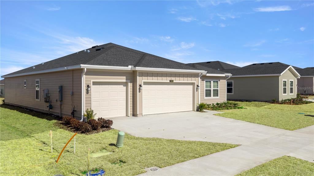 6896 Southwest 87th Street Ocala, FL 34476 - Photo 2 of 5 a front view of a house with a yard and garage