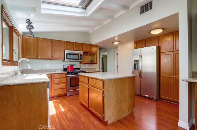 a kitchen with stainless steel appliances granite countertop a refrigerator stove and sink