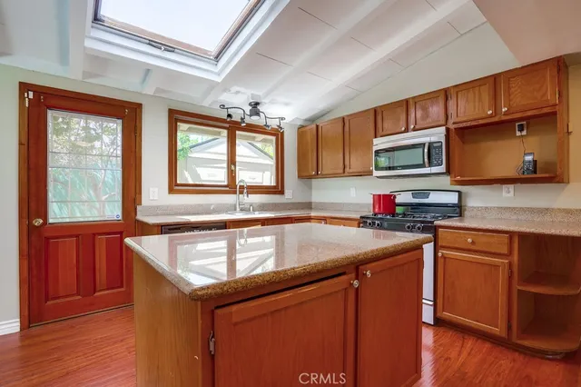 a kitchen with granite countertop a sink stove and cabinets