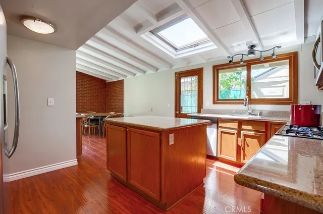 a kitchen with stainless steel appliances granite countertop wooden floors and sink
