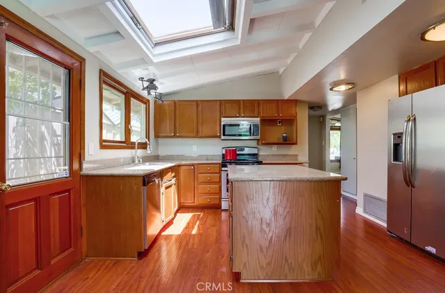 a kitchen with stainless steel appliances wooden floors and wooden cabinets