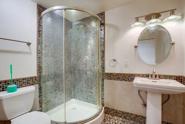 a bathroom with a sink mirror toilet and shower