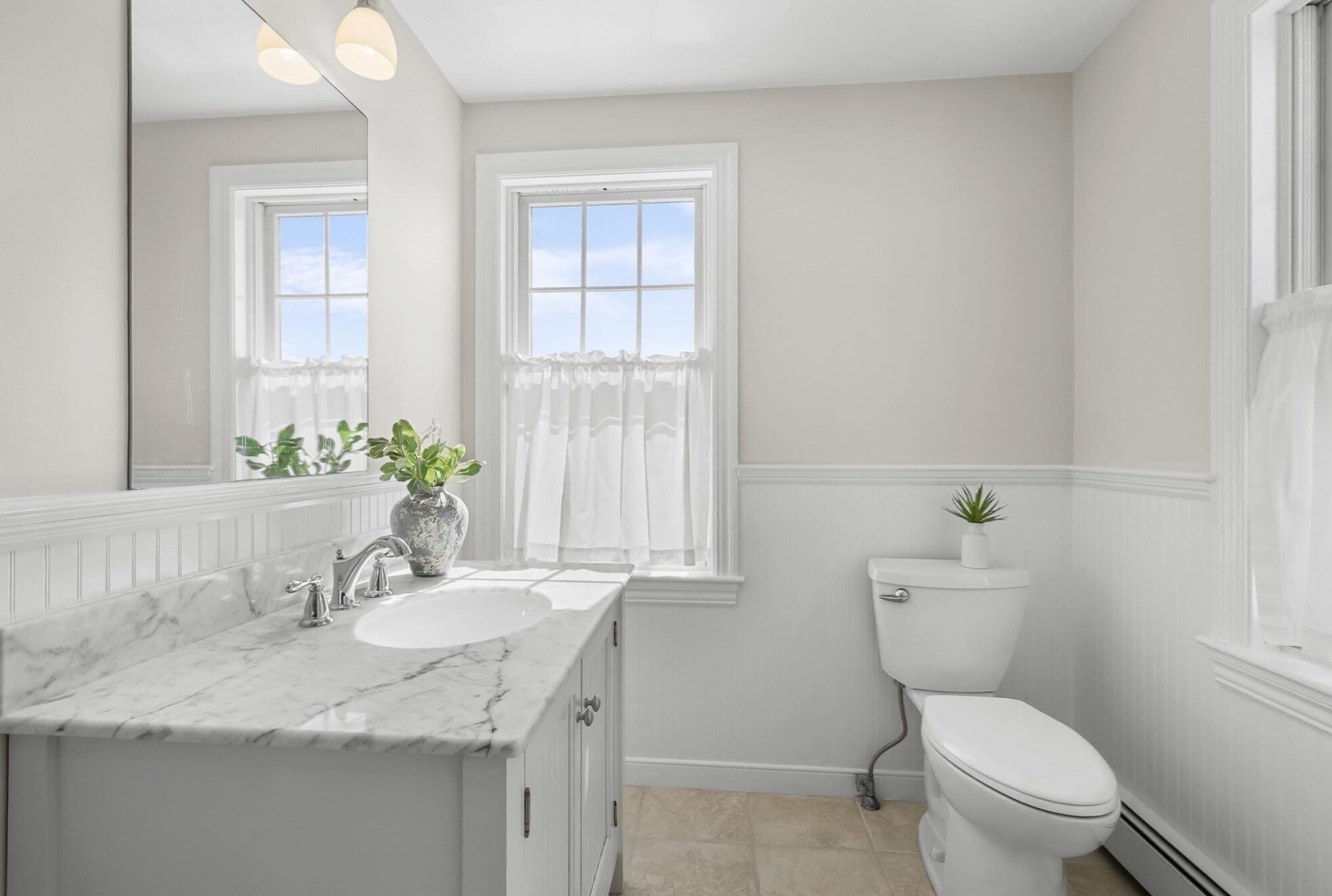 67 Phillips Road Sagamore Beach, MA 02562 - Photo 16 of 34 a bathroom with a granite countertop toilet a sink and a window