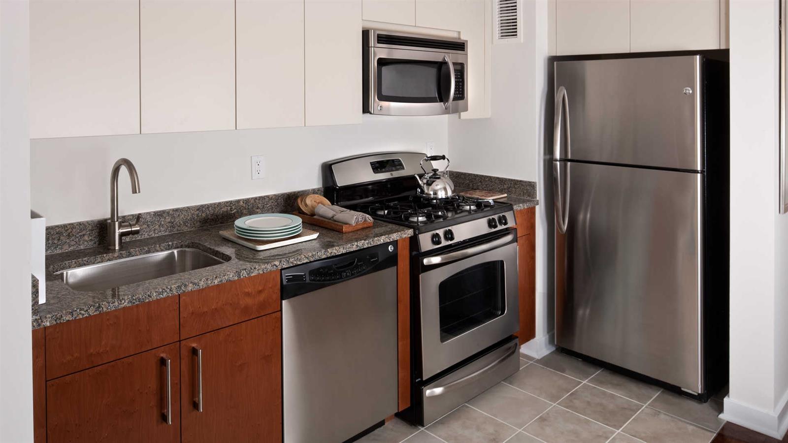 111 Lawrence Street, Unit 31J Brooklyn, NY 11201 - Photo 3 of 10 a kitchen with granite countertop stainless steel appliances and wooden cabinets