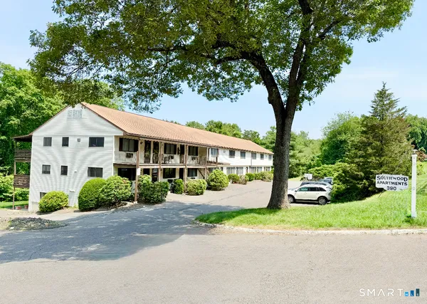 a front view of a house with a yard and trees