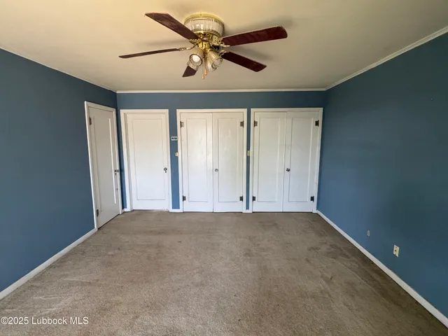 an empty room with chandelier fan