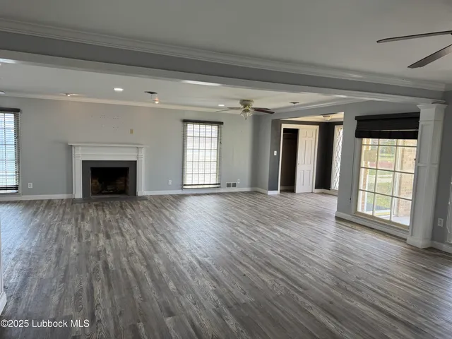 wooden floor fireplace and windows in an empty room