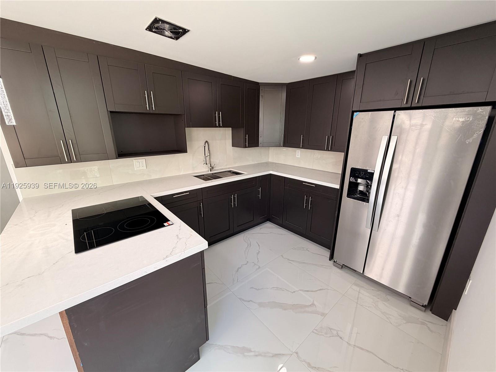 3527 Northwest 17th Street Miami, FL 33125 - Photo 2 of 16 a kitchen with a refrigerator sink and cabinets