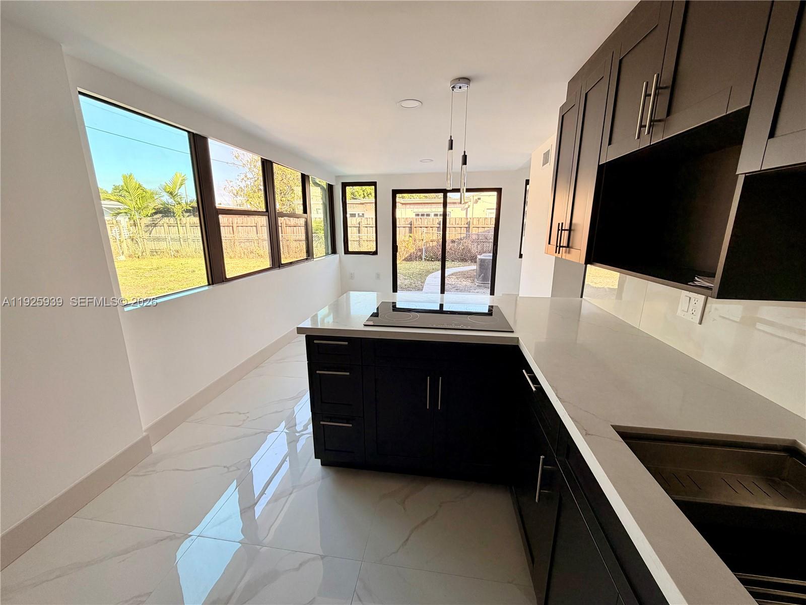 3527 Northwest 17th Street Miami, FL 33125 - Photo 3 of 16 a kitchen with a large window and a flat screen tv