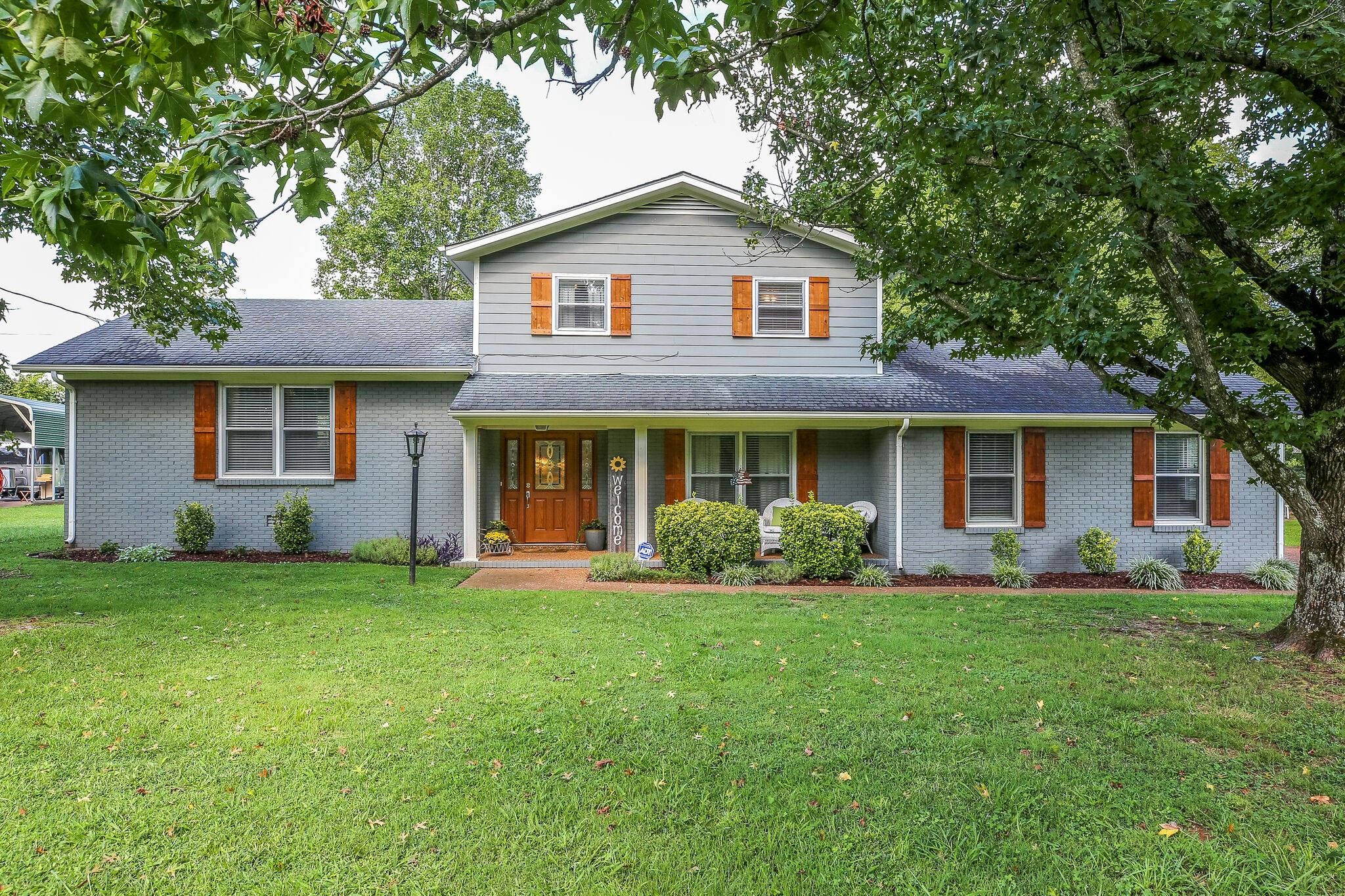 a front view of a house with a garden and yard