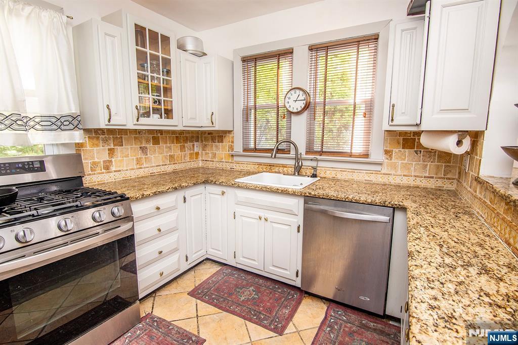 847 Red Road Teaneck, NJ 07666 - Photo 8 of 20 a kitchen with stainless steel appliances granite countertop a stove a sink and a microwave