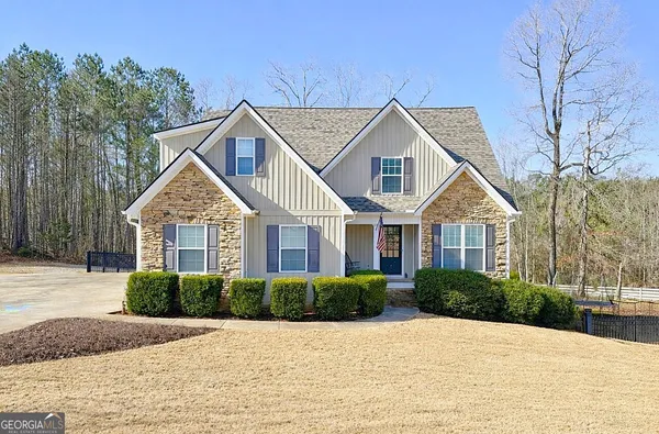 a front view of a house with a yard and trees