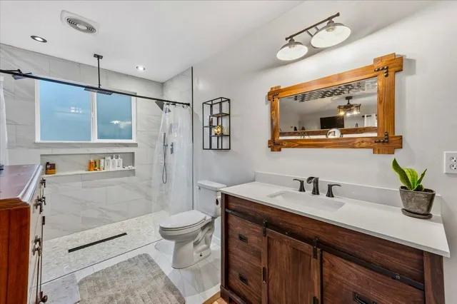 a bathroom with a sink a toilet and shower