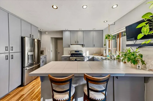 a kitchen with granite countertop a sink and a refrigerator
