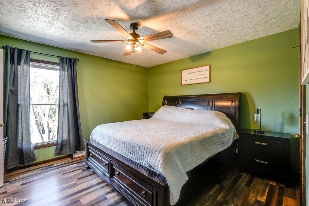 1157 Bass Circle Northwest Canton, OH 44708 - Photo 14 of 31 Bedroom with dark wood finished floors, a textured ceiling, and a ceiling fan